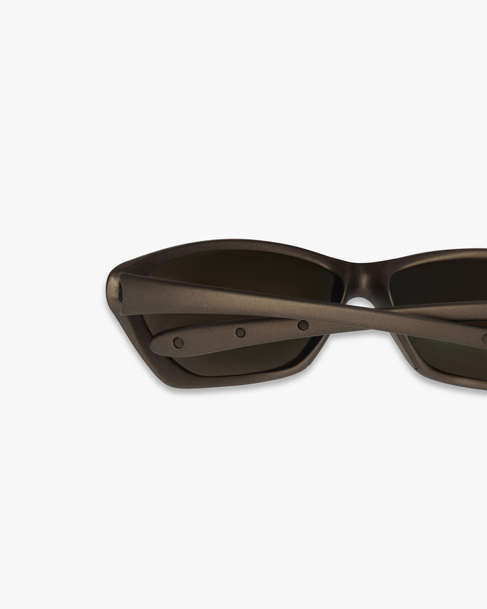 Close-up of bronze sunglasses on a plain white background | 247 Arena Sunglasses in Bronze | Sunglasses with mirrored lenses and rubberised grip | 247 Accessories | Represent Clo