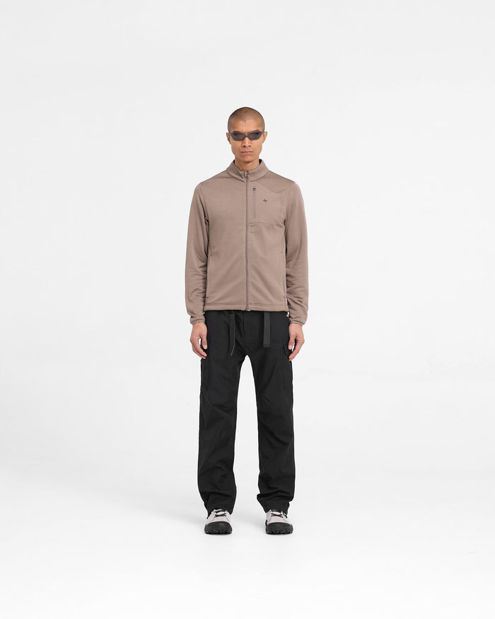 Man wearing a brown zip fleece on a plain white background | 247 Full Zip Fleece in Umber | Fleece jacket with zip chest pocket | 247 Outerwear | Represent Clo