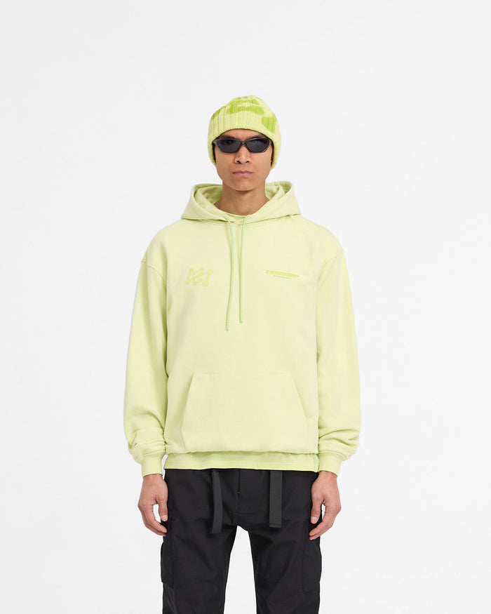 Man wearing an oversized lime hoodie on a plain white background | 247 Future Terrains Oversized Hoodie in Shadow Lime | Heavyweight cotton hoodie with tonal branding | 247 Hoodies | Represent Clo
