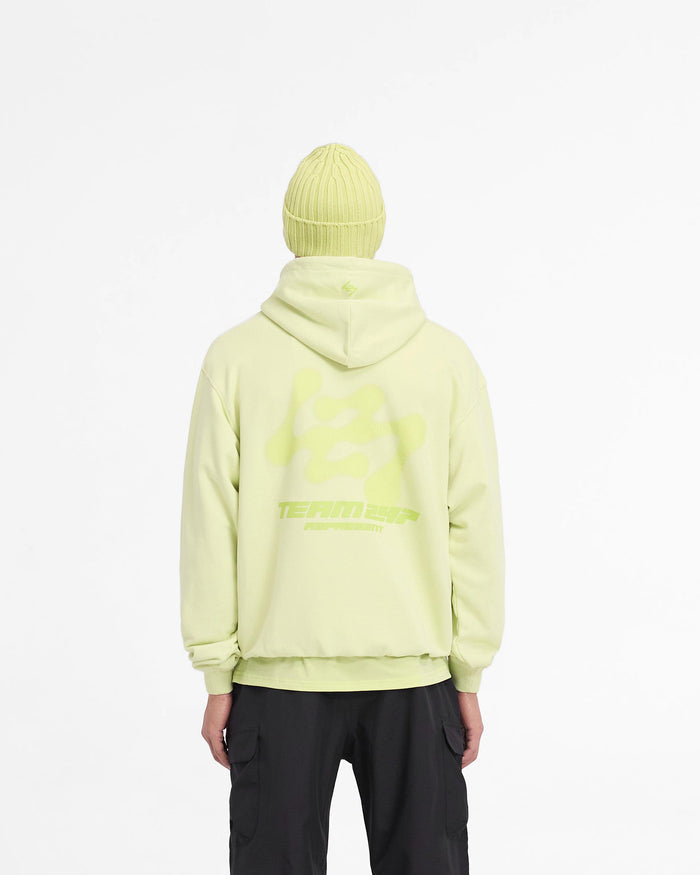 Man wearing an oversized lime hoodie on a plain white background | 247 Future Terrains Oversized Hoodie in Shadow Lime | Oversized hoodie with tonal branding and ribbed cuffs | 247 Hoodies | Represent Clo