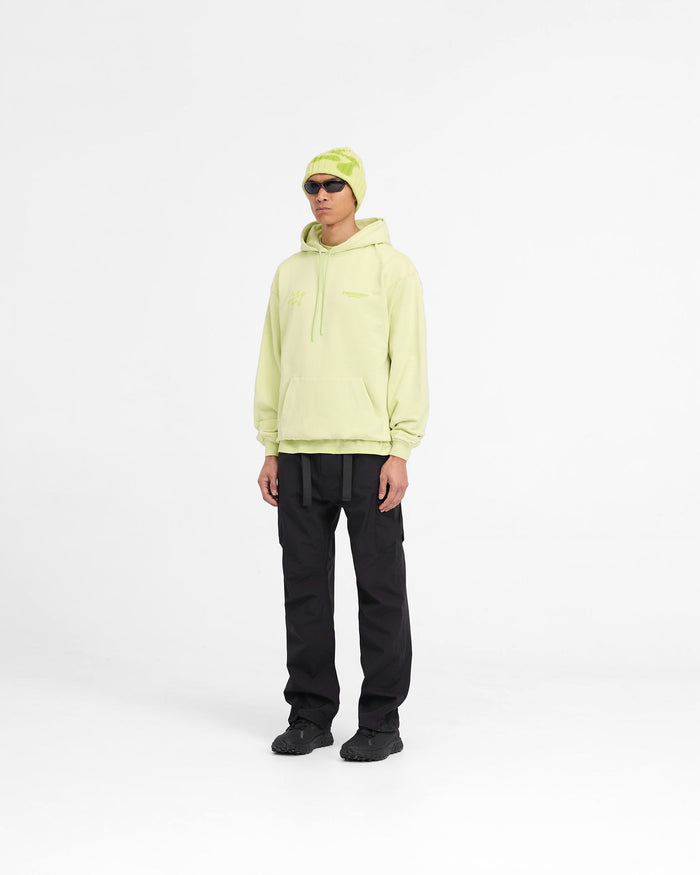 Man wearing an oversized shadow lime hoodie on a plain white background | 247 Future Terrains Oversized Hoodie in Shadow Lime | Heavyweight cotton hoodie with tonal branding and ribbed hem | 247 Hoodies | Represent Clo
