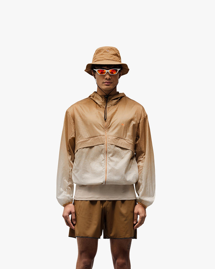 Man wearing an ombre hooded jacket on a plain white background | 247 Hooded Training Jacket in Ombre | Hooded jacket with mesh lining and adjustable toggles | 247 Outerwear | Represent Clo