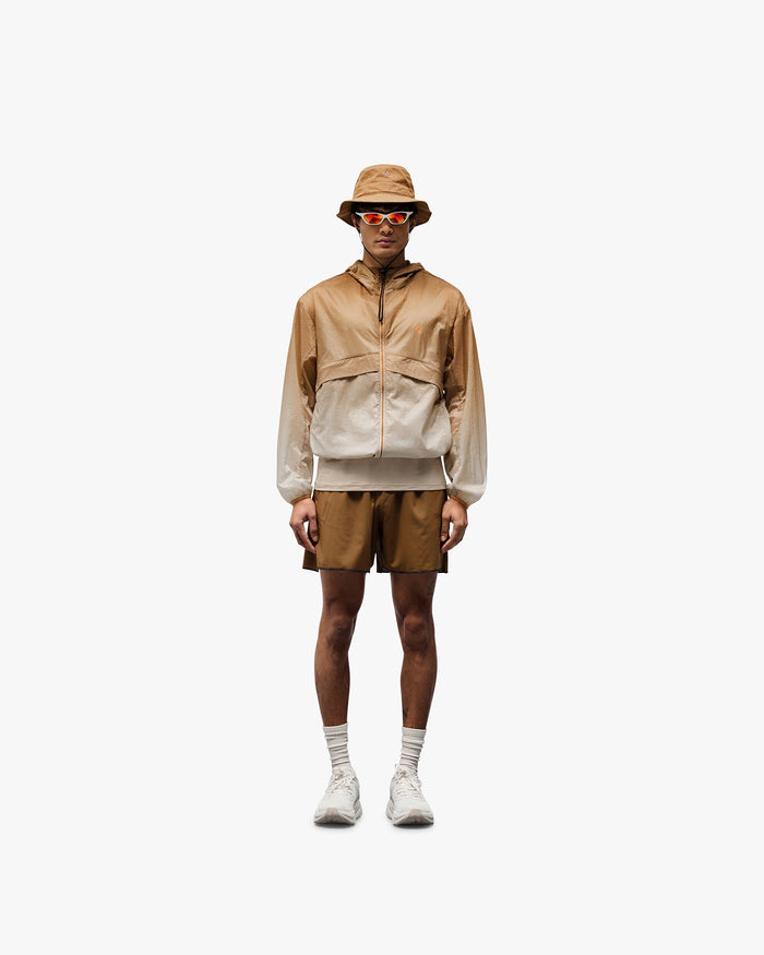Man wearing a grey hooded training jacket on a plain white background | 247 Hooded Training Jacket in Ombre | Performance jacket with water resistance and adjustable features | 247 Outerwear | Represent Clo