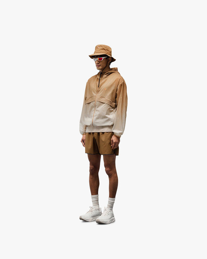 Man wearing a grey hooded training jacket on a plain white background | 247 Hooded Training Jacket in Ombre | Polyester jacket with DWR coating | 247 Outerwear | Represent Clo