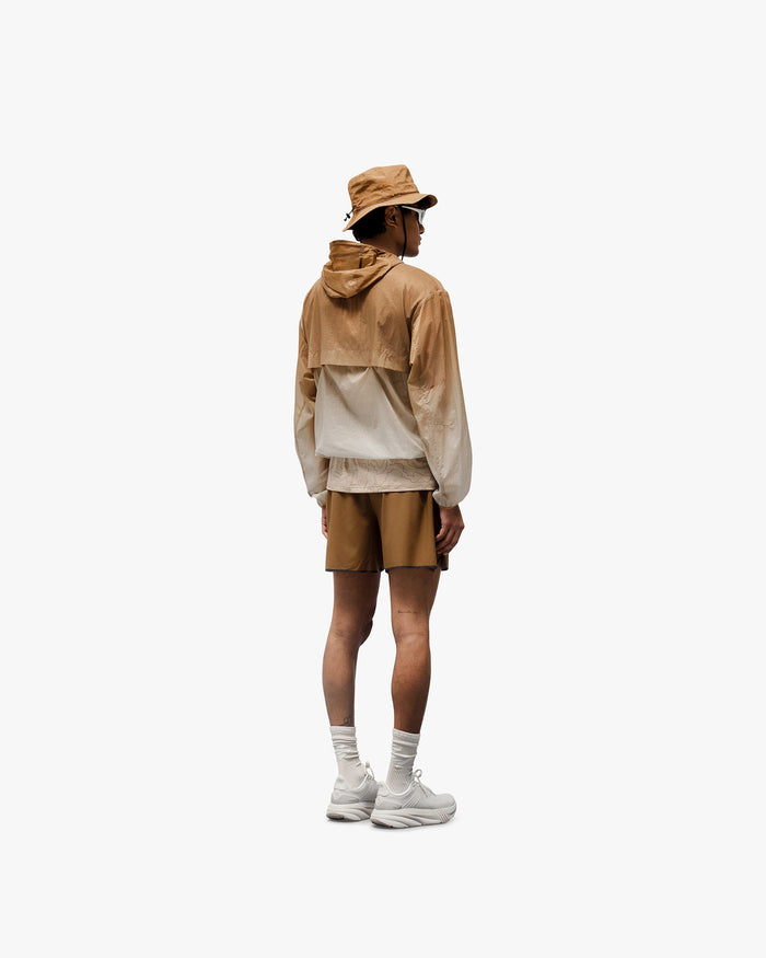 Man wearing a grey hooded jacket on a plain white background | 247 Hooded Training Jacket in Ombre | Hooded jacket with DWR coating and elastic thumb straps | 247 Outerwear | Represent Clo