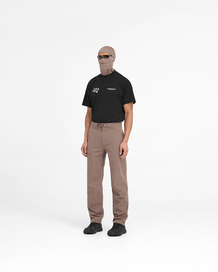 Man wearing umber pants on a plain white background | 247 Mission Pant in Umber | Straight leg pants with built-in belt and zip pockets | 247 Pants | Represent Clo