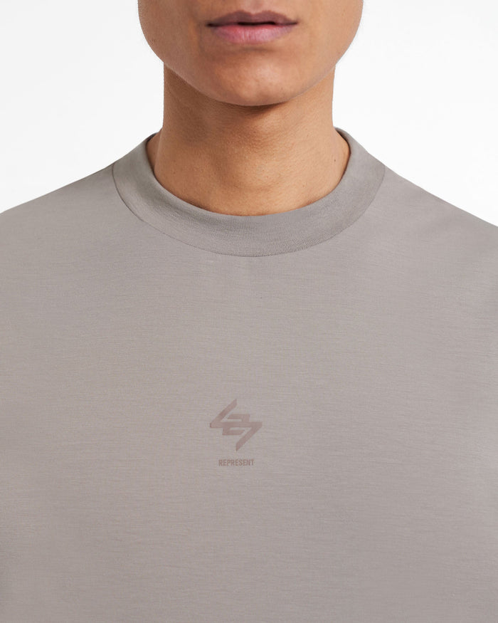 Man wearing a grey oversized tank top on a plain white background | 247 Oversized Tank in Cinder | Technical fabric tank with 4-way stretch | 247 T-Shirts | Represent Clo