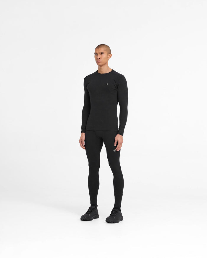 Man wearing a black ribbed long sleeve top on a plain white background | 247 Ribbed Long Sleeve Top in Black | Thermal base layer t-shirt with close fit | 247 T-Shirts | Represent Clo