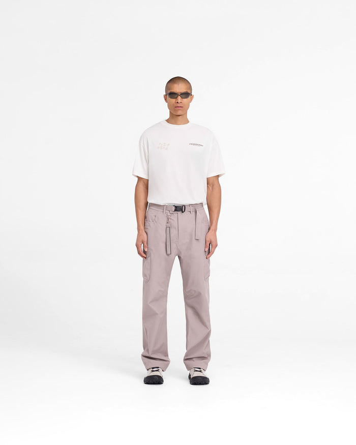 Man wearing grey cargo pants on a plain white background | 247 Technical Cargo Pant in Moonrock | Waterproof technical cargo pants with maglock buckle and knee darts | 247 Pants | Represent Clo