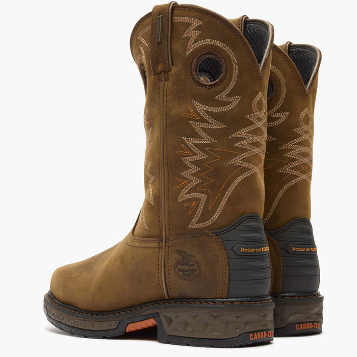 Pair of brown cowboy boots with intricate stitching on a white background