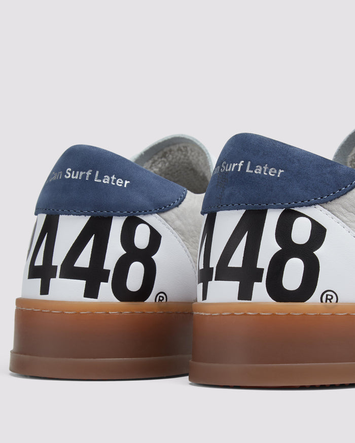 Side angle of beige and navy sneakers