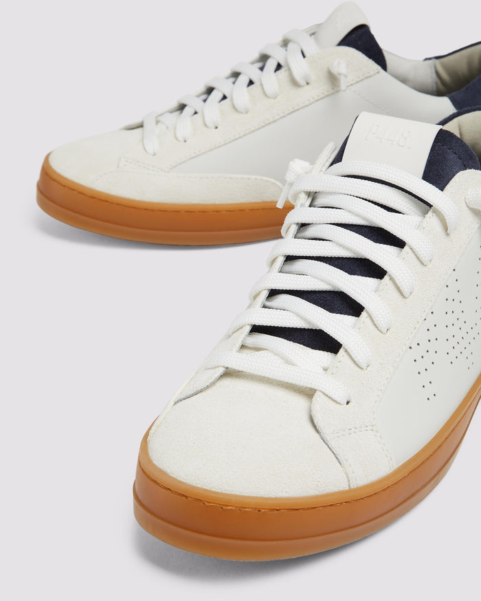 Side angle of white and navy sneakers