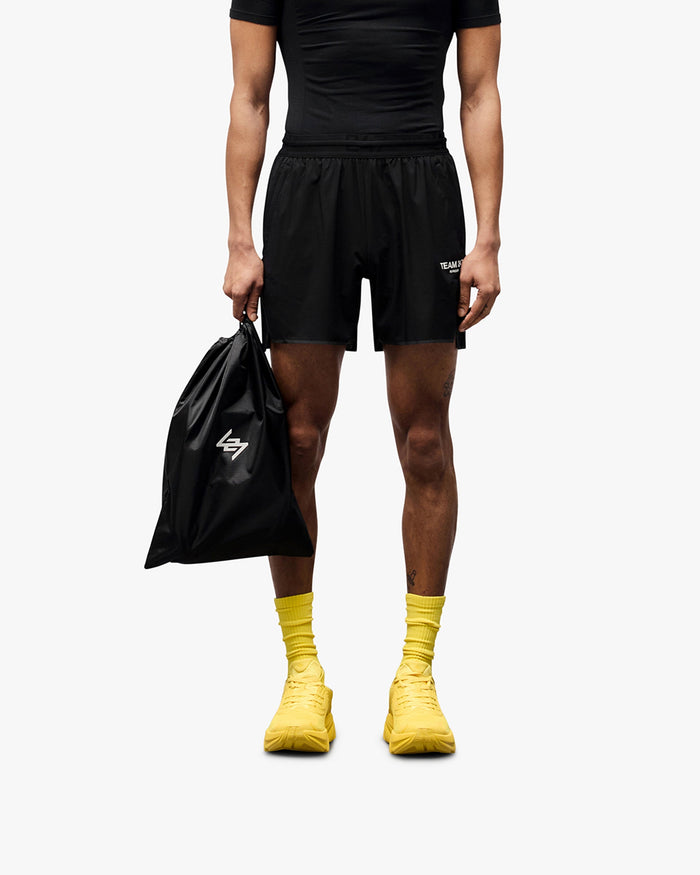 Man wearing black running shorts on a plain white background | Team 247 Aero Short in Black | Lightweight breathable running shorts with branded waistband | 247 Shorts | Represent Clo