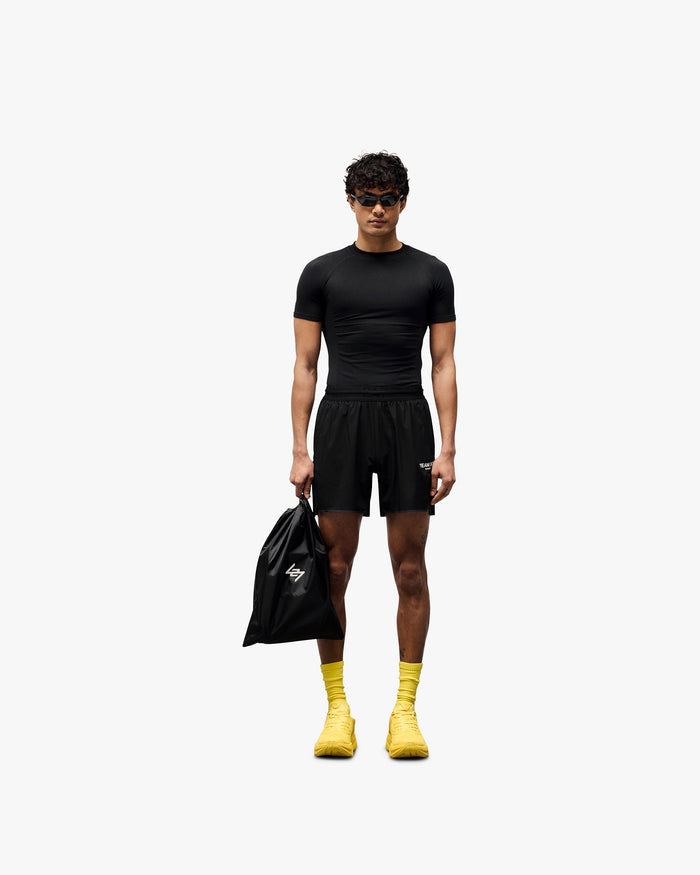 Man wearing black running shorts on a plain white background | Team 247 Aero Short in Black | Lightweight breathable running shorts with a branded waistband | 247 Shorts | Represent Clo