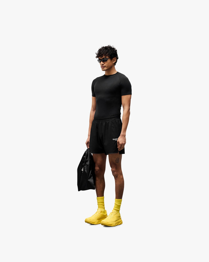Man wearing black shorts on a plain white background | Team 247 Aero Short in Black | Lightweight running shorts with branded waistband and zip pockets | 247 Shorts | Represent Clo