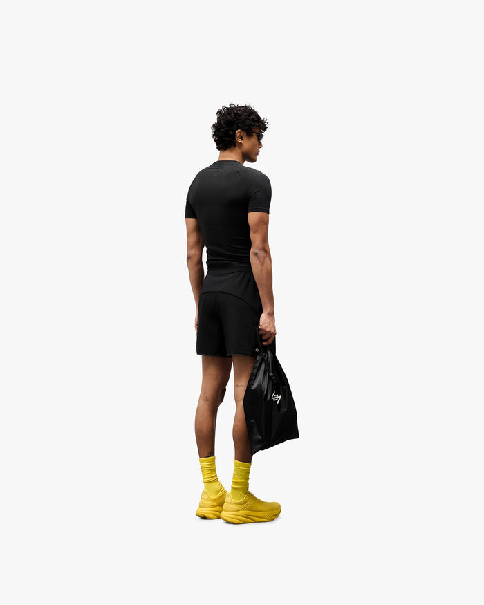 Man wearing black lightweight running shorts on a plain white background | Team 247 Aero Short in Black | Running shorts with branded waistband and zip pockets | 247 Shorts | Represent Clo